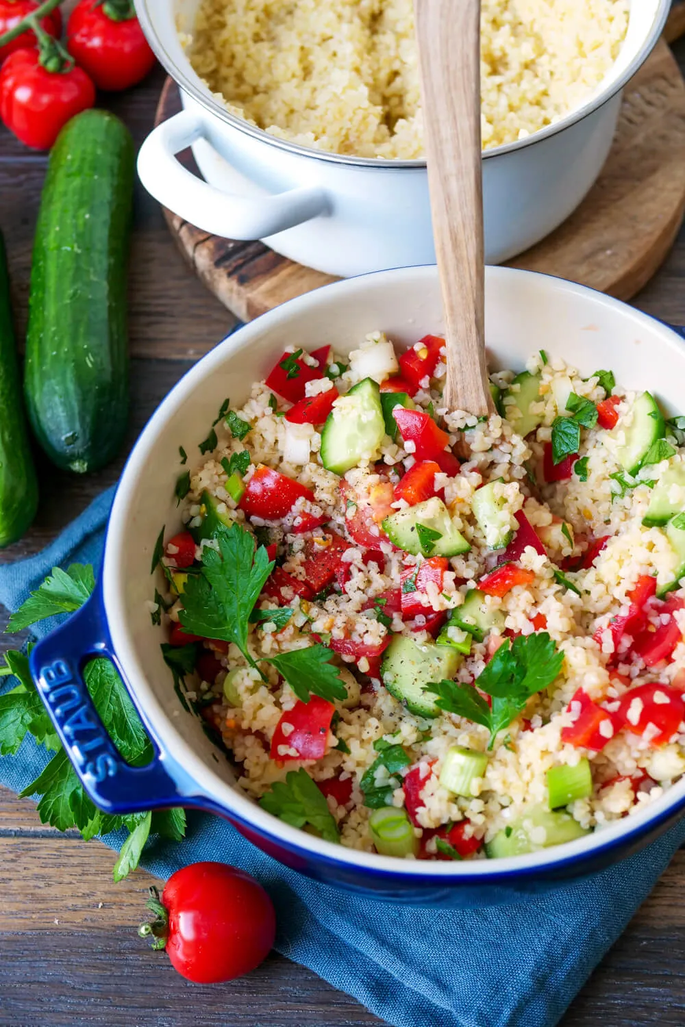Bereiteter Bulgur mit frischer Gurke, Paprika und Kräutern für einen Salat.