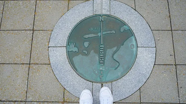 Bild von oben auf die Plakette des 7. Längengrades auf Juist