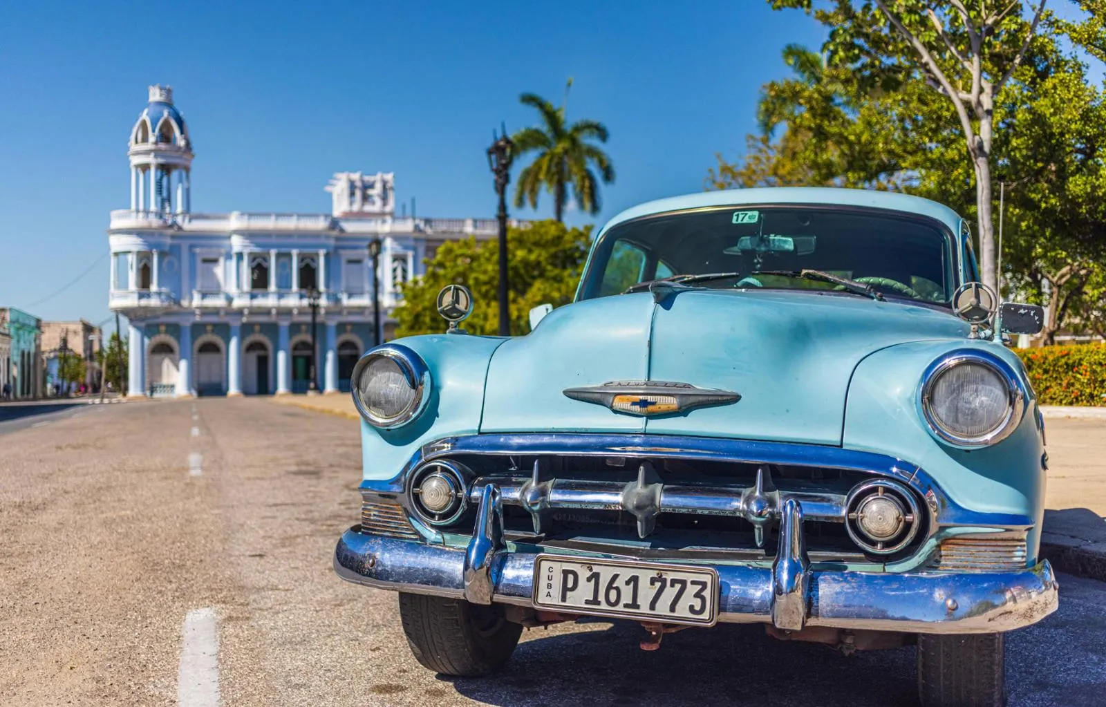 Blauer Oldtimer am El Parque Jose Marti in Cienfuegos auf Kuba vor historischen Gebäuden