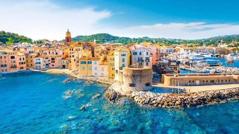 Blick auf den malerischen Hafen von Saint-Tropez mit luxuriösen Yachten und farbenfrohen Gebäuden im Sonnenlicht
