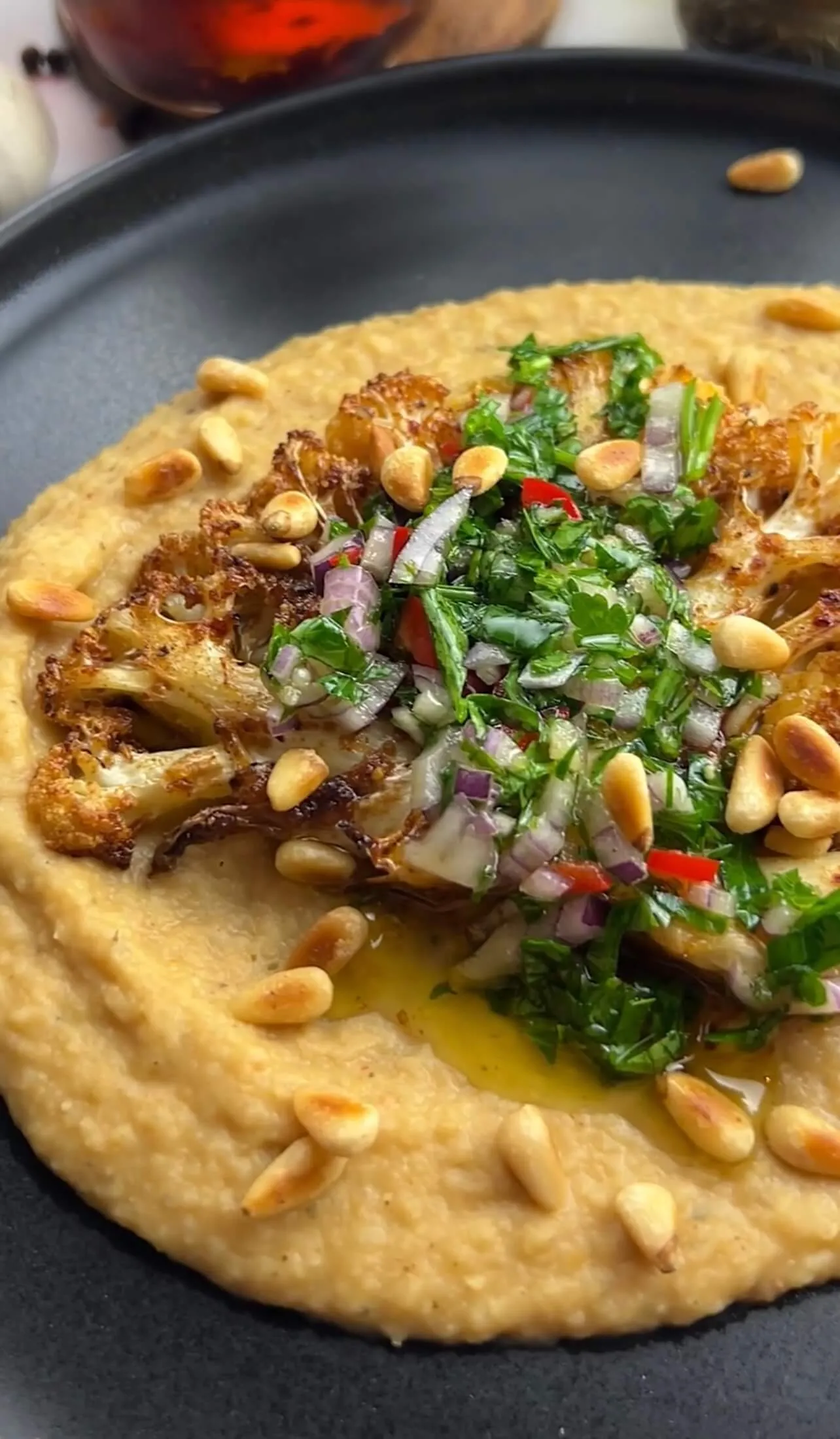 Blumenkohlsteaks mit Chimichurri-Sauce und Bohnenpüree auf einem Teller