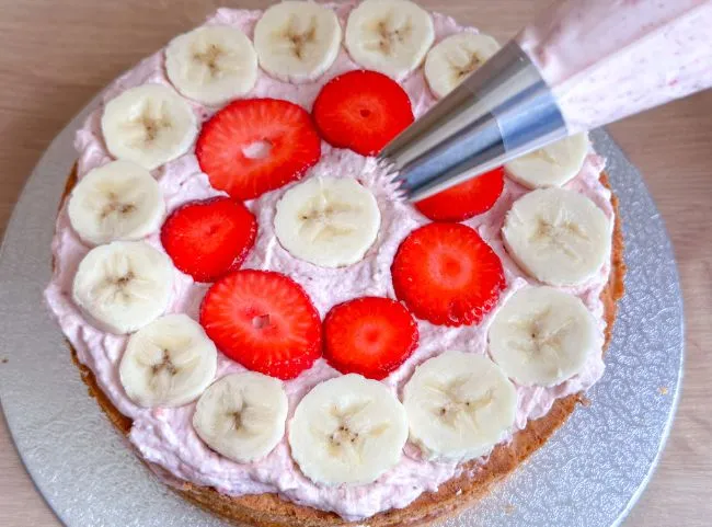 Creme auf der Babytorte verteilen