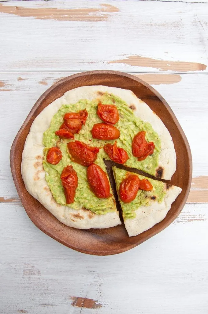 Cremige Avocado-Pizza mit gerösteten Tomaten, eine frische Belag-Alternative