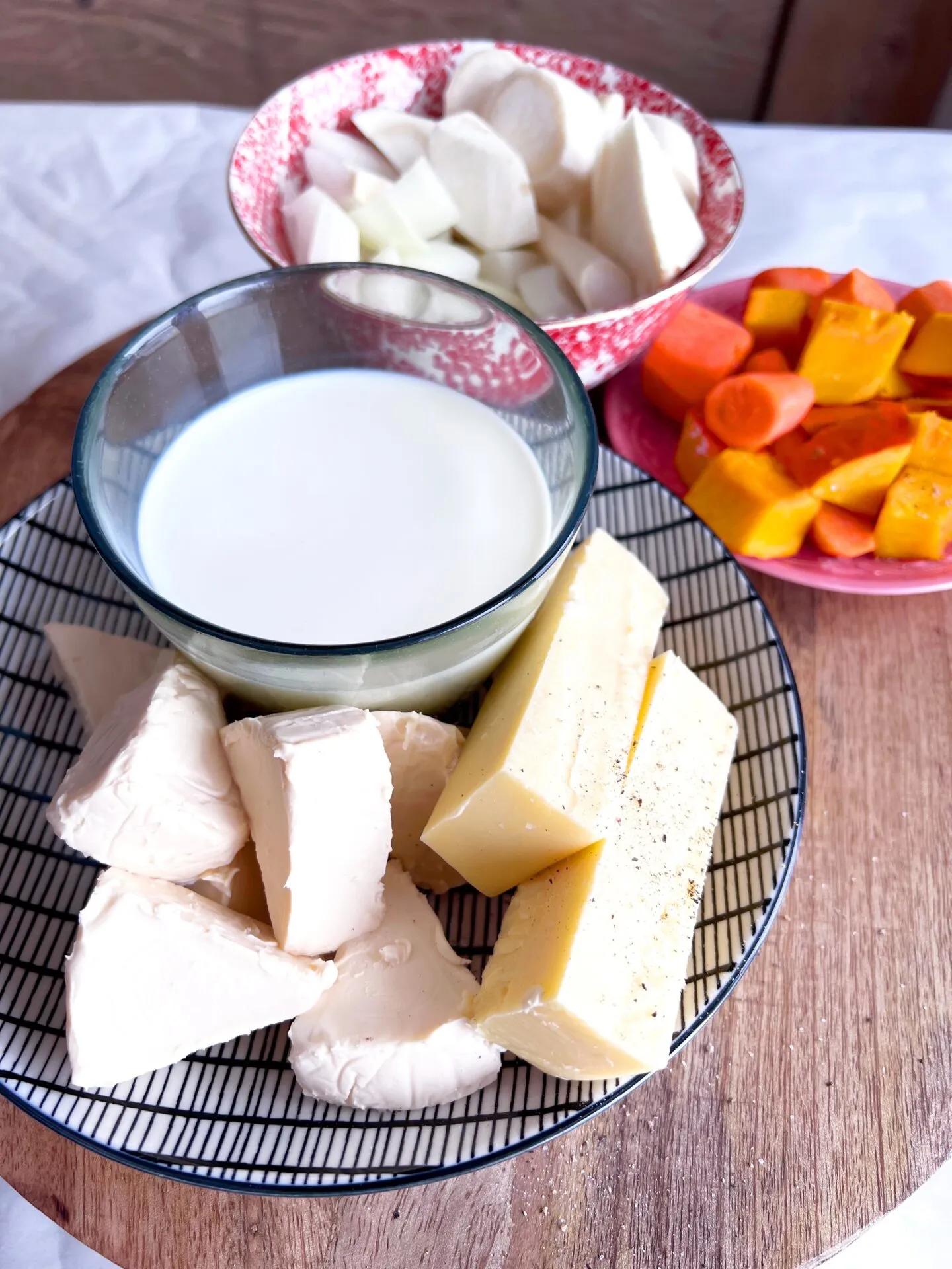 Cremige goldene Käsesoße in einer Edelstahlschüssel mit einem Schneebesen