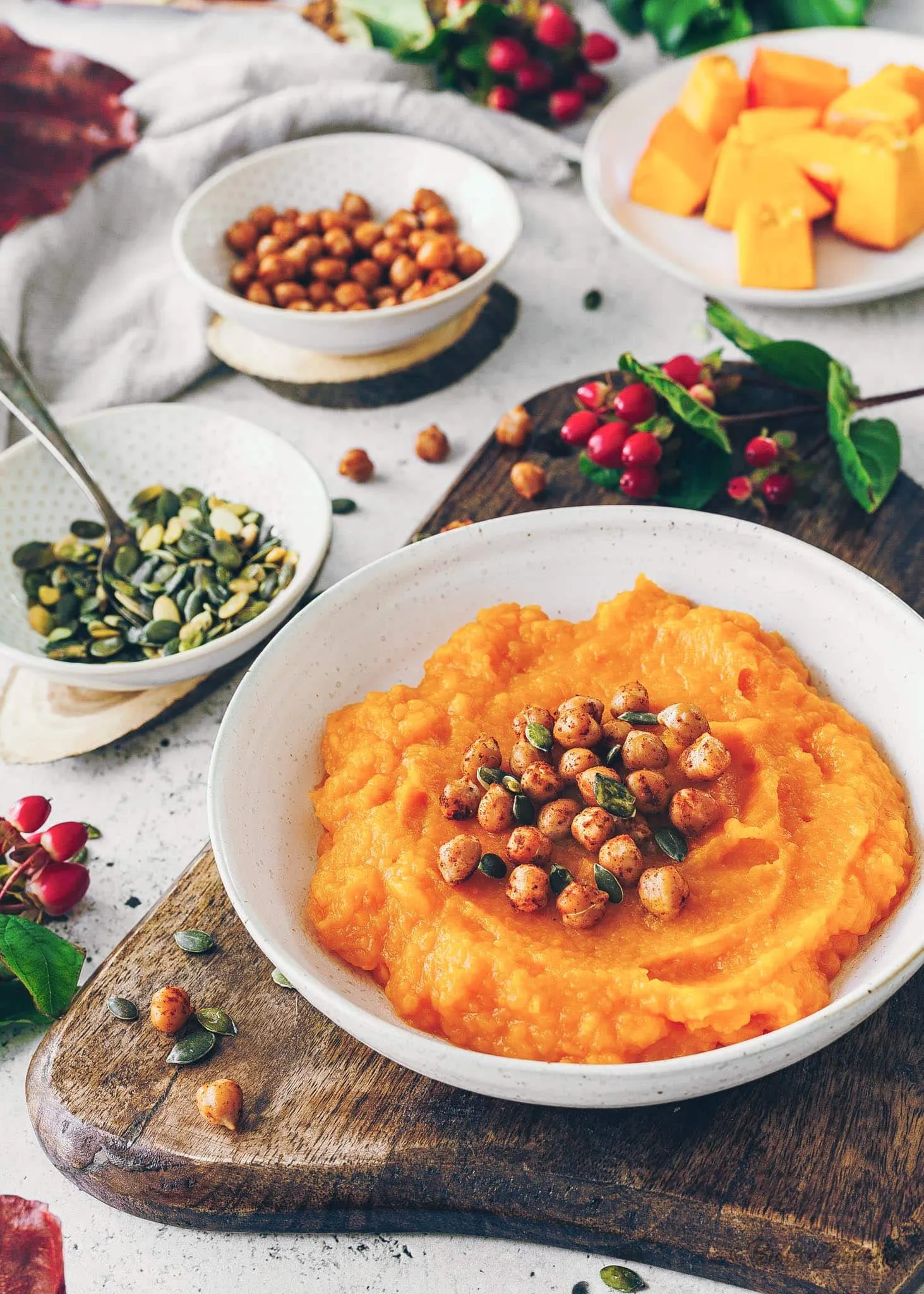 Cremiges Kürbispüree, garniert mit Kichererbsen und Kürbiskernen, bereit zum Servieren