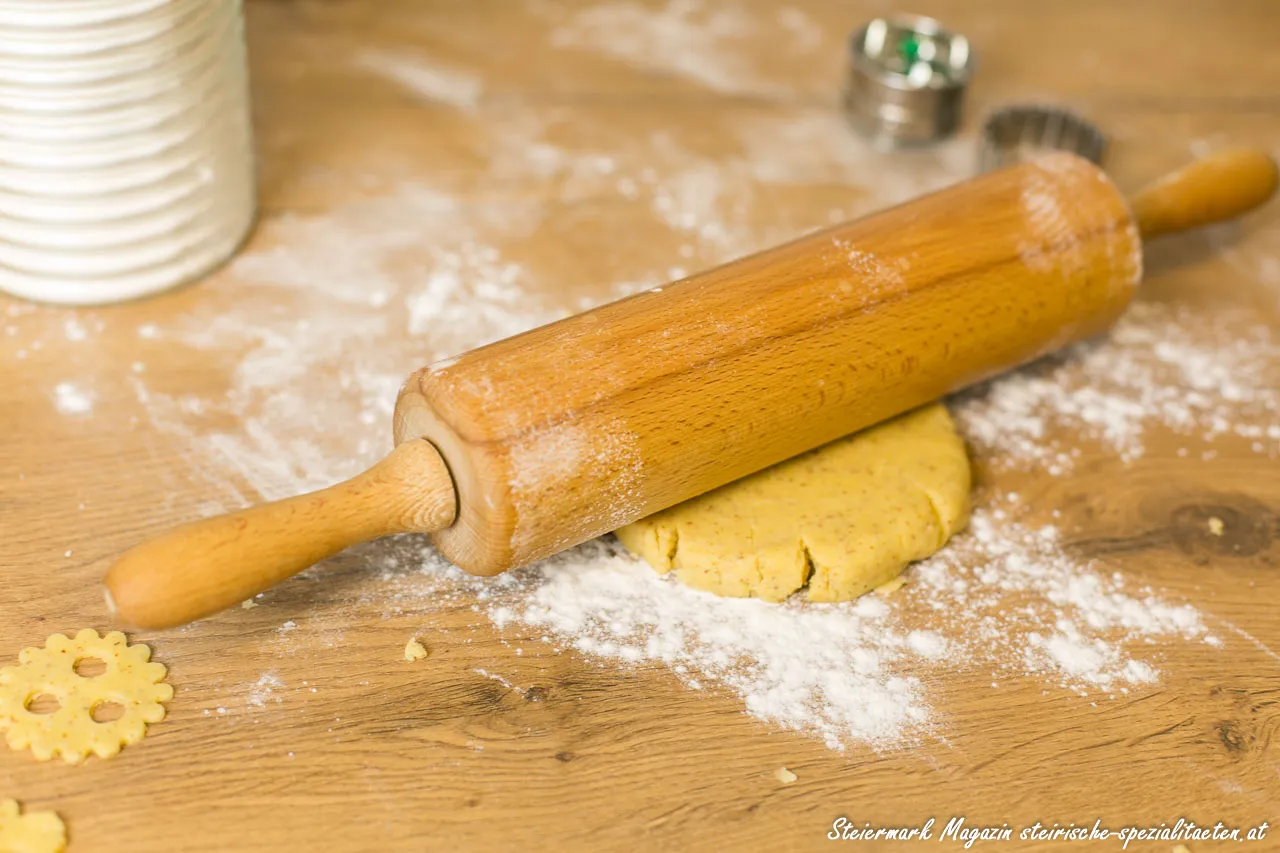 Das Ausrollen des Mürbteigs für Linzer Augen auf einer bemehlten Arbeitsfläche