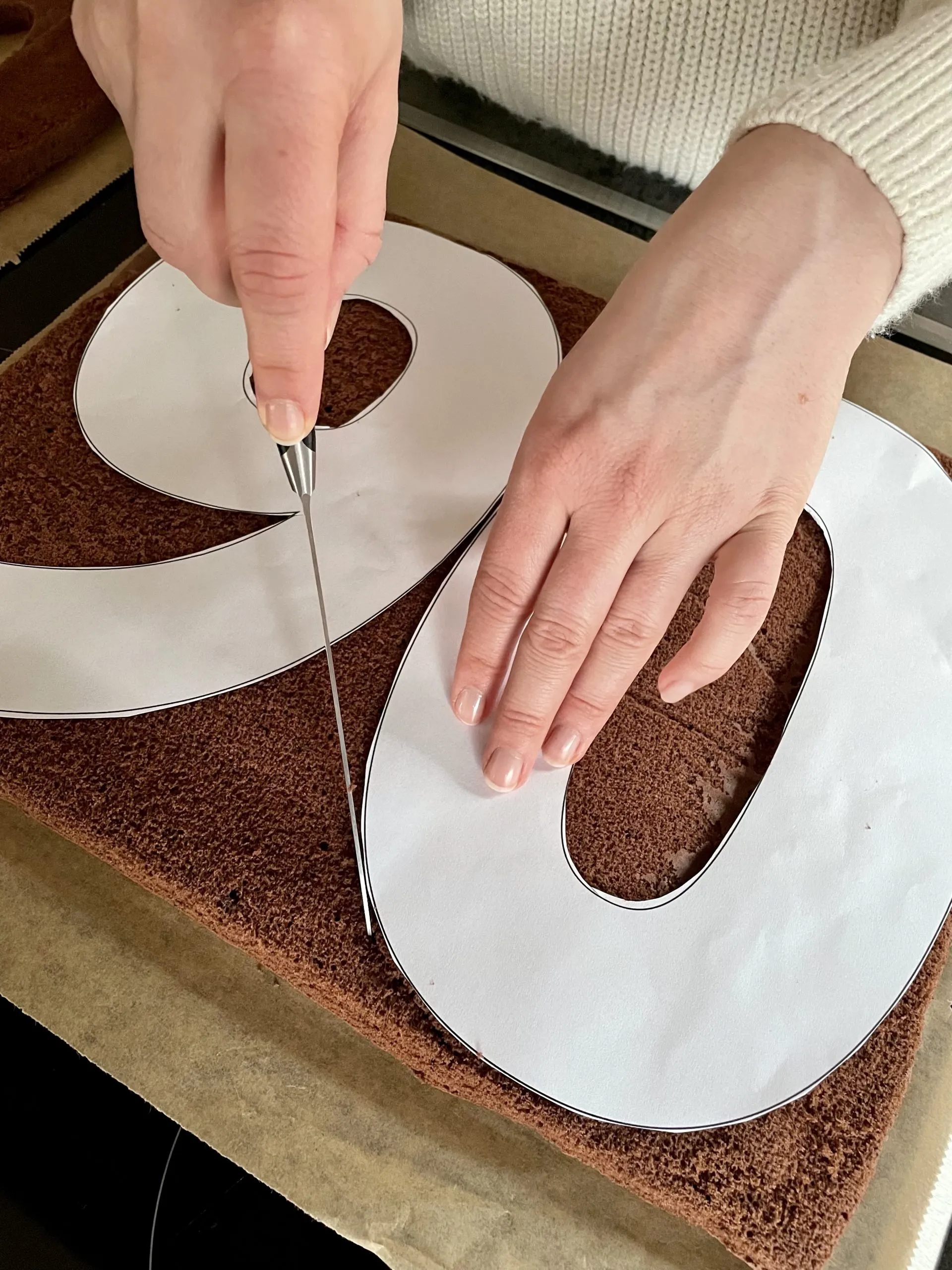 Das Ausschneiden der Zahl '6' aus dem fertig gebackenen Biskuitboden