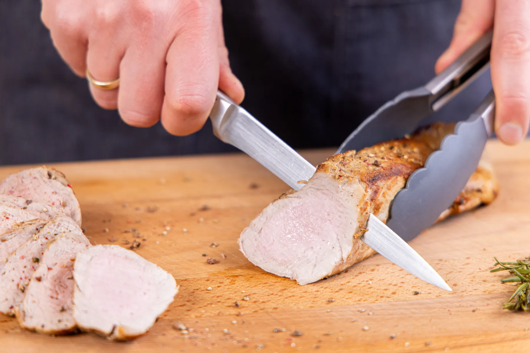 Das fertig gebratene Schweinefilet wird in Scheiben geschnitten, um seine Zartheit und Saftigkeit zu demonstrieren.