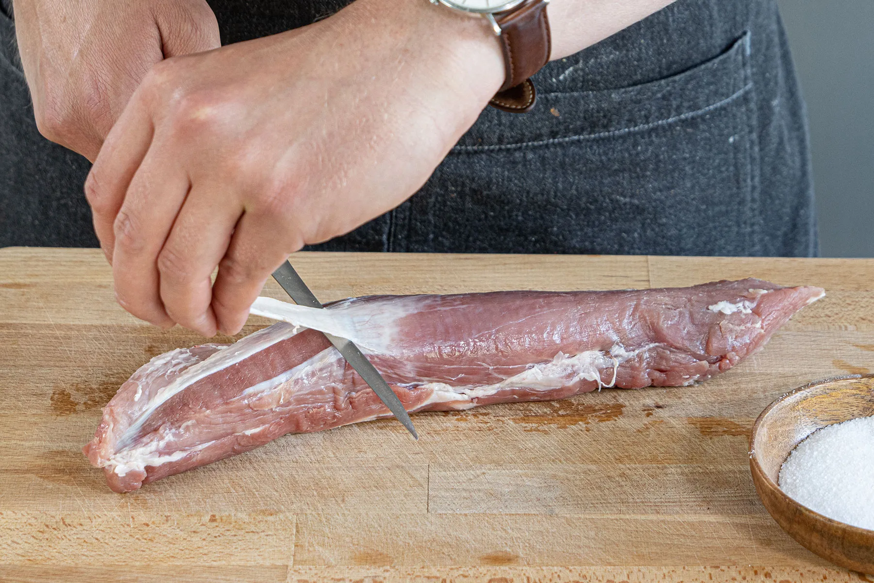 Das Schweinefilet wird sorgfältig von überschüssigem Fett und Sehnen befreit, bevor es gebraten wird.