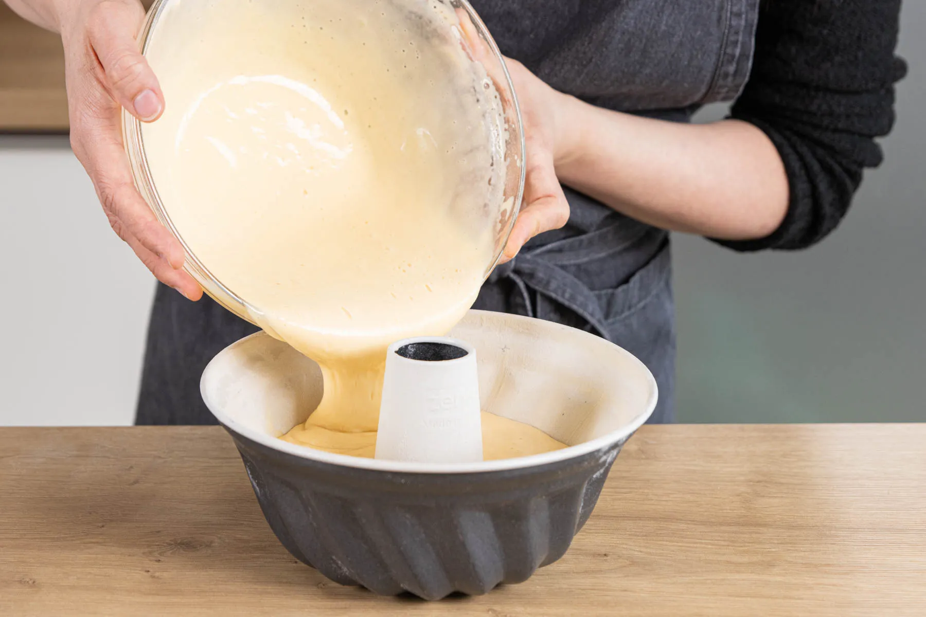 Den hellen Teig gleichmäßig in die vorbereitete Gugelhupfform füllen