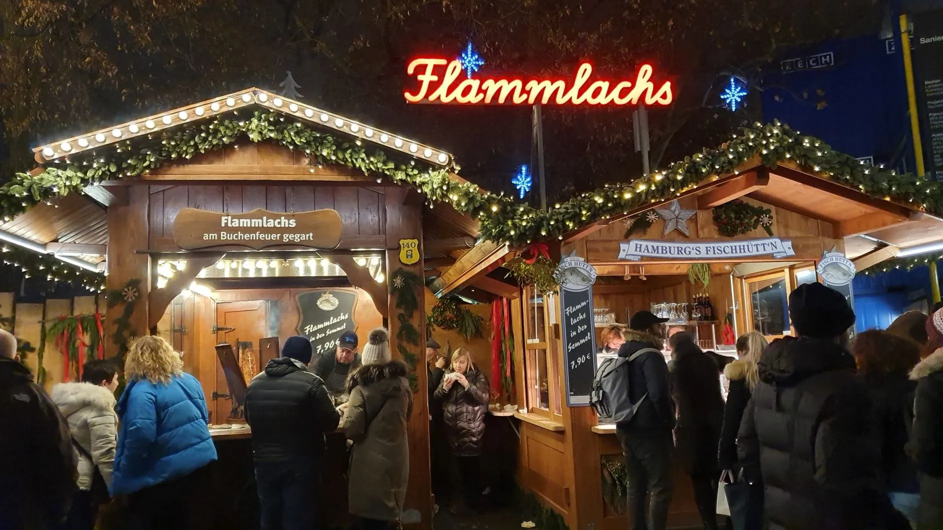 Der belebte Stand "Hamburgs FischHutt'n" auf einem deutschen Weihnachtsmarkt