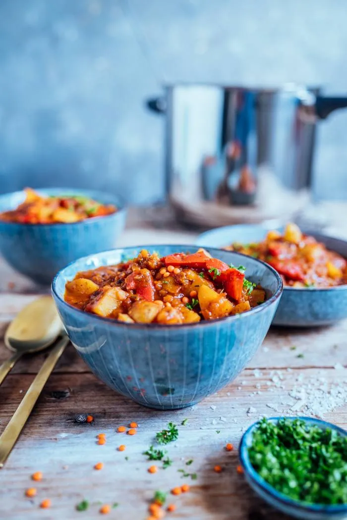 Der Paprika-Kartoffel-Linsen-Topf köchelt langsam auf dem Herd, die Zutaten vermischen sich zu einem aromatischen Gericht