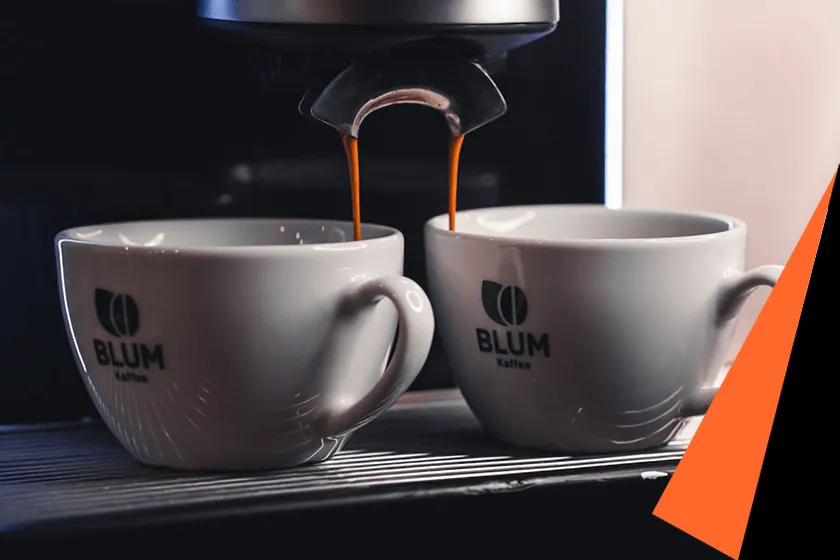 Detailansicht einer modernen Kaffeemaschine in einer professionellen Gastronomieumgebung, die frisch zubereiteten Kaffee ausschenkt