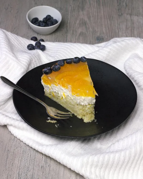 Detailaufnahme der frischen Mandarinenstücke auf der Tortenoberfläche vor dem Aufgießen des Gusses