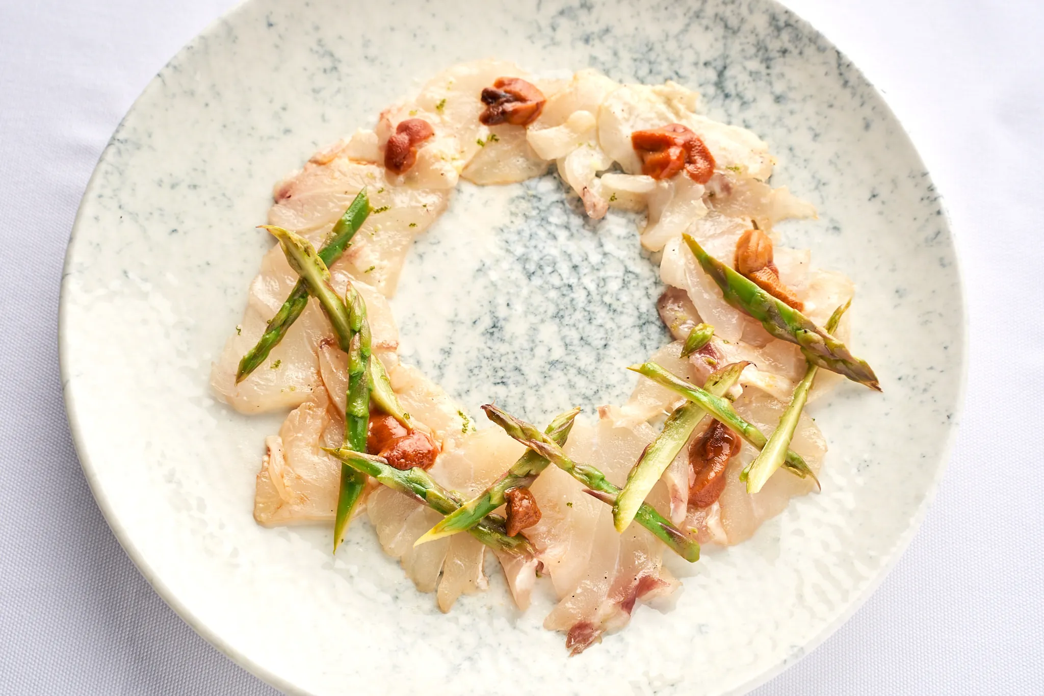 Detailaufnahme eines Hauptgerichts mit frischem Fisch und Gemüse, kunstvoll arrangiert