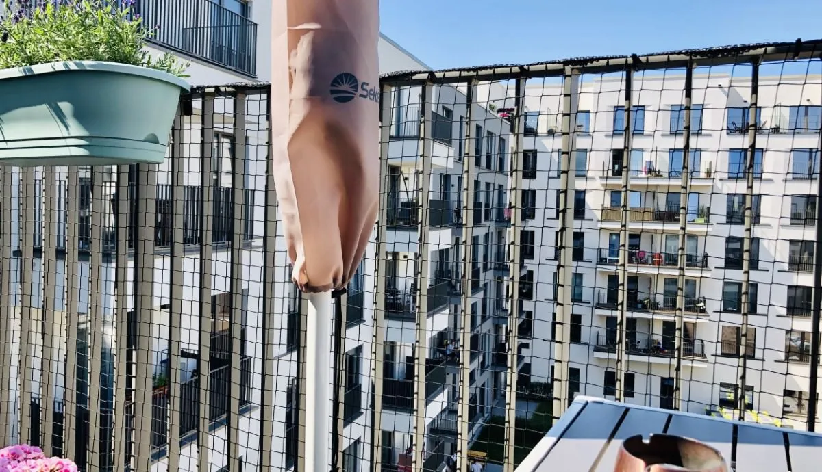 Detailaufnahme eines Katzennetzes, das sicher an einem Balkongeländer befestigt ist.