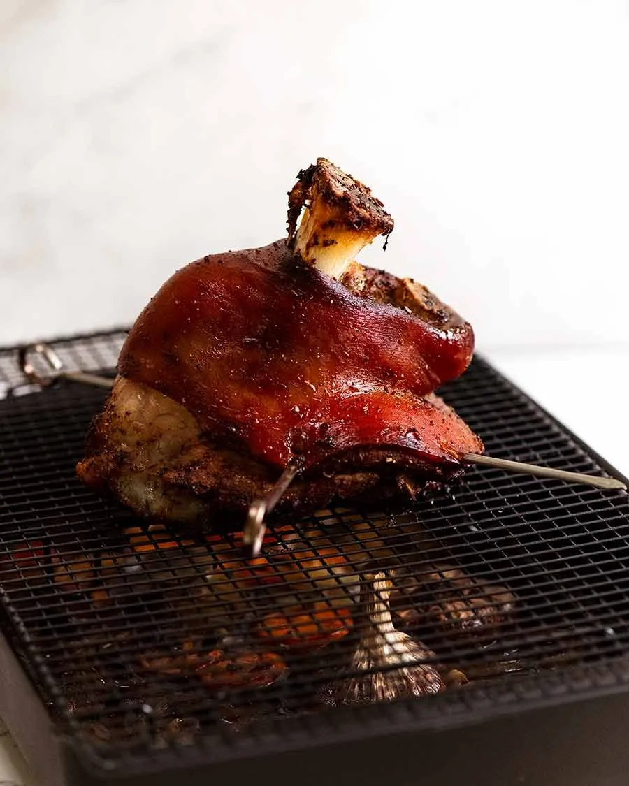 Deutsche Schweinshaxe nach der langsamen Bratphase, bereit für die finale Knusprigkeit der Schwarte im heißen Ofen