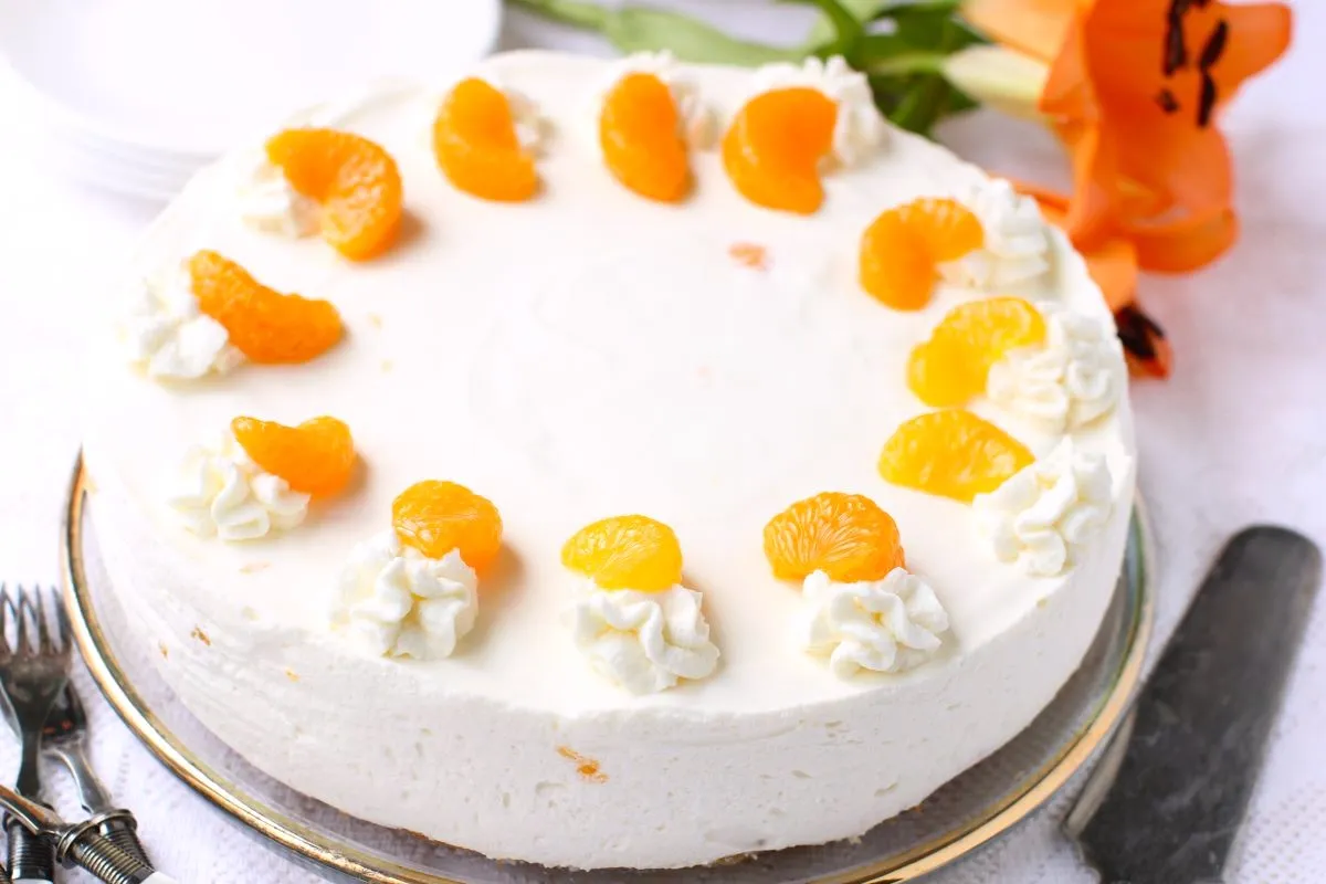 Die gesamte Mandarinen-Sahnetorte, dekoriert und bereit zum Anschneiden.