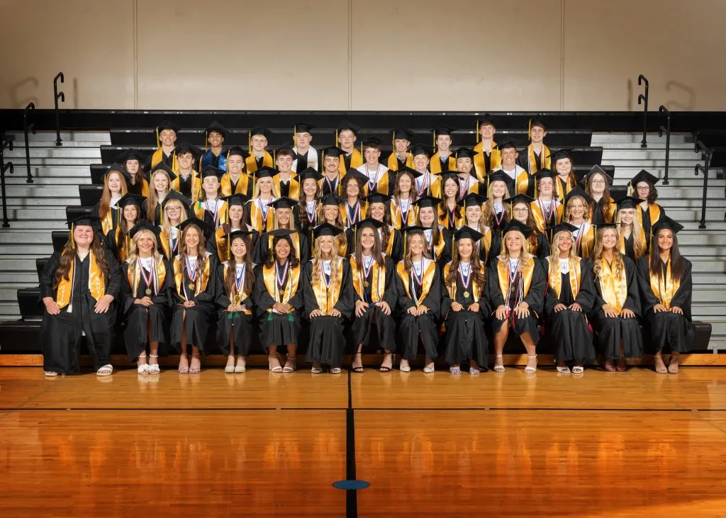 Die Gruppe der Absolventen der Klasse von 2025 posiert stolz zusammen in ihren Roben