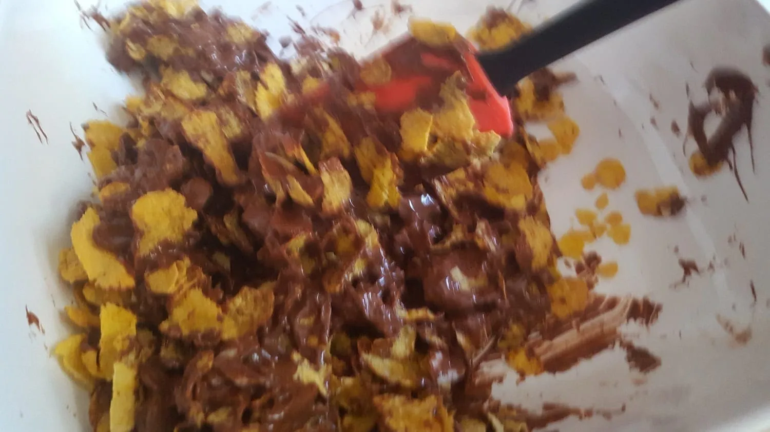 Die Mischung aus Cornflakes, Mandeln und Schokolade wird sorgfältig verrührt