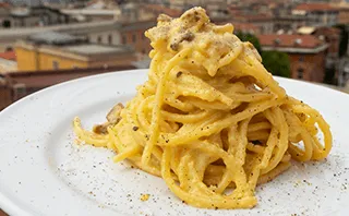 Drei einfache Schritte zur Zubereitung von Spaghetti Carbonara, die die Textur der Sauce und die knusprigen Guanciale-Stücke hervorheben