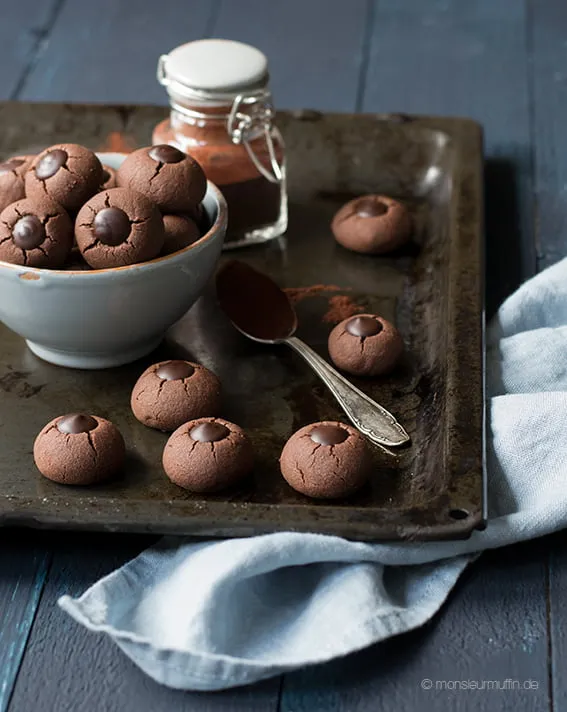 Dunkle Schokoladenkekse mit Kakaobohnensplittern, fertig gebacken und mit Schokoladenfüllung