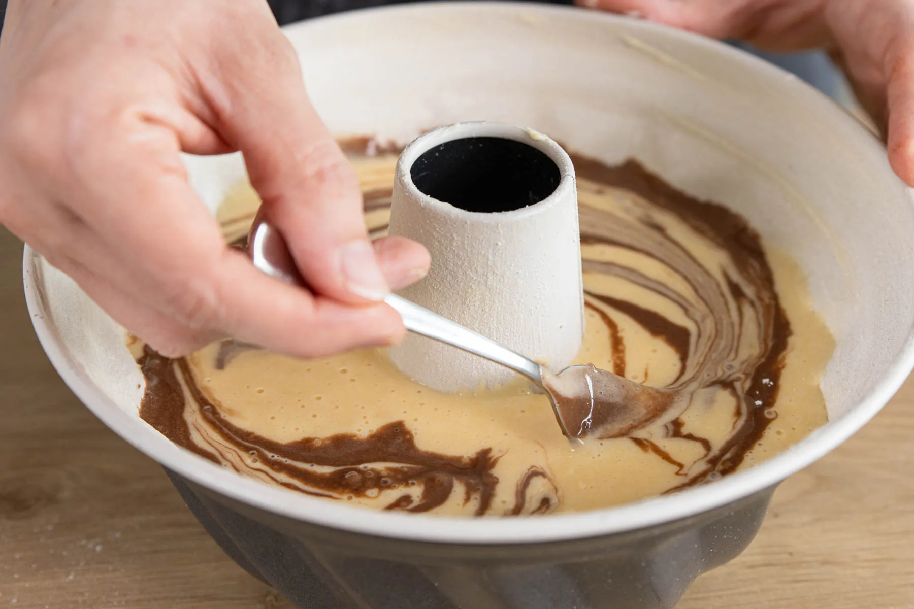 Dunklen und hellen Teig vorsichtig miteinander vermischen, um das typische Marmormuster zu erzeugen