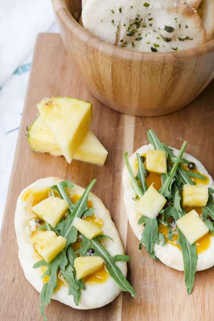 Dünn ausgerollter Fladenbrotteig auf einem Holzbrett, bereit zum Backen oder Braten.
