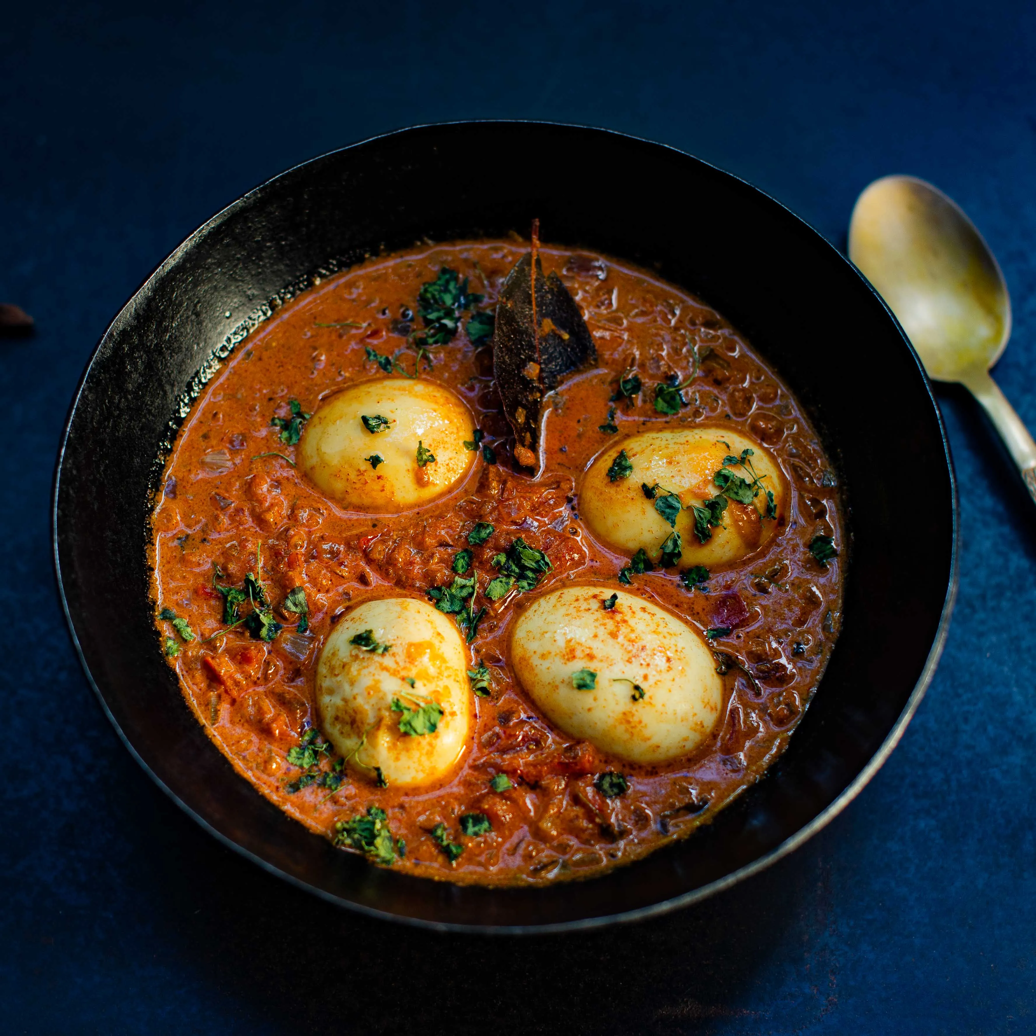 Egg Curry mit Eiern in einer würzigen roten Sauce, garniert mit Koriander