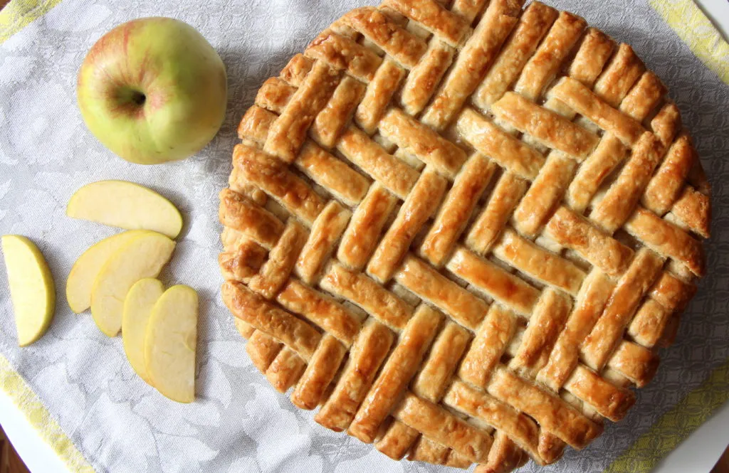 Ein amerikanischer Apfelkuchen kurz vor dem Backen, kunstvoll verziert mit einem Fischgrätenmuster auf dem Teigdeckel
