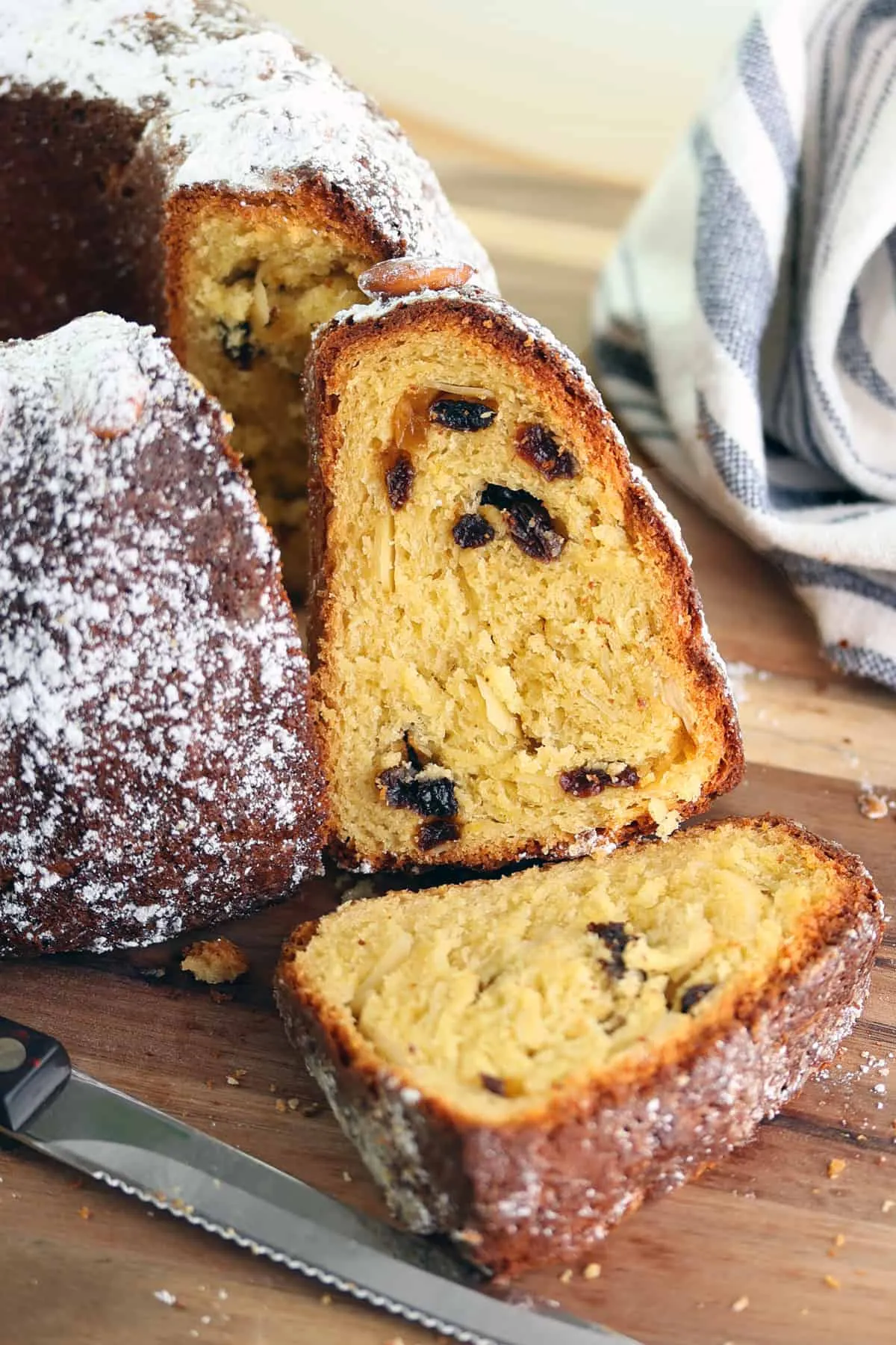 Ein angeschnittener Gugelhupf, der seine saftige Textur und die Verteilung der Rosinen und Mandeln zeigt