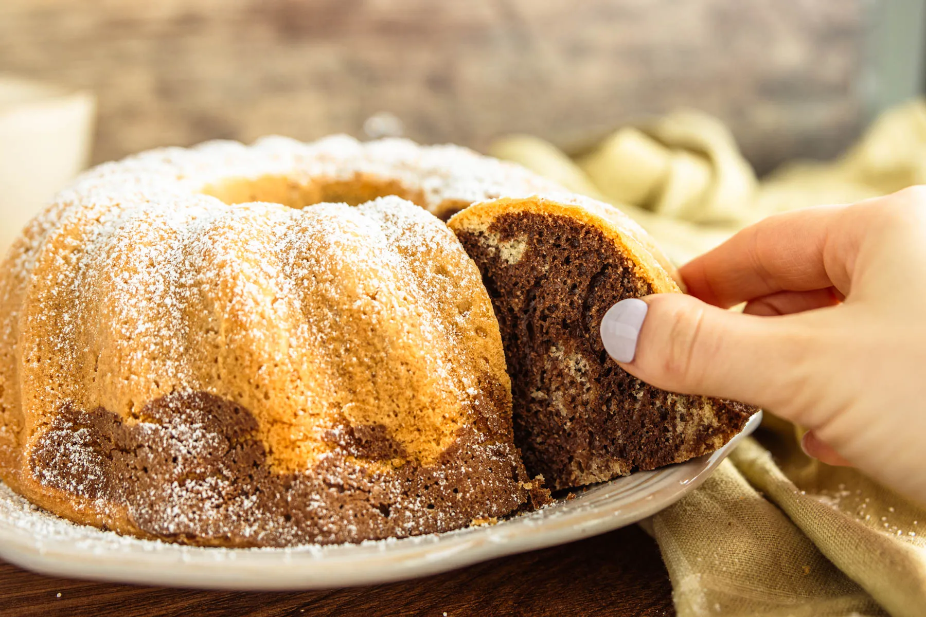 Ein angeschnittener Marmorkuchen ohne Butter, der seine wunderbar saftige Textur und die klassische Marmorierung zeigt