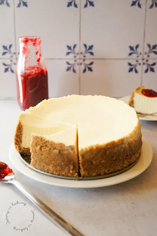 Ein angeschnittener New York Cheesecake mit goldbraunem Boden und cremiger Füllung