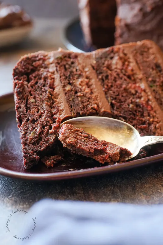 Ein Anschnitt der saftigen Schoko-Zucchini-Torte, die ihre dunkle Schokoladenfüllung und -glasur offenbart