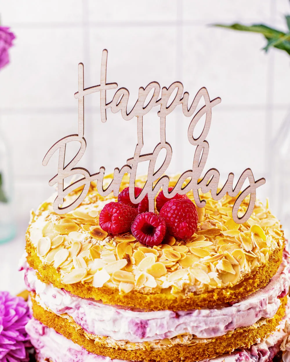 Ein Anschnitt des Himbeer-Quark Naked Cakes, der die cremig-fruchtige Füllung und die Mandelböden hervorhebt