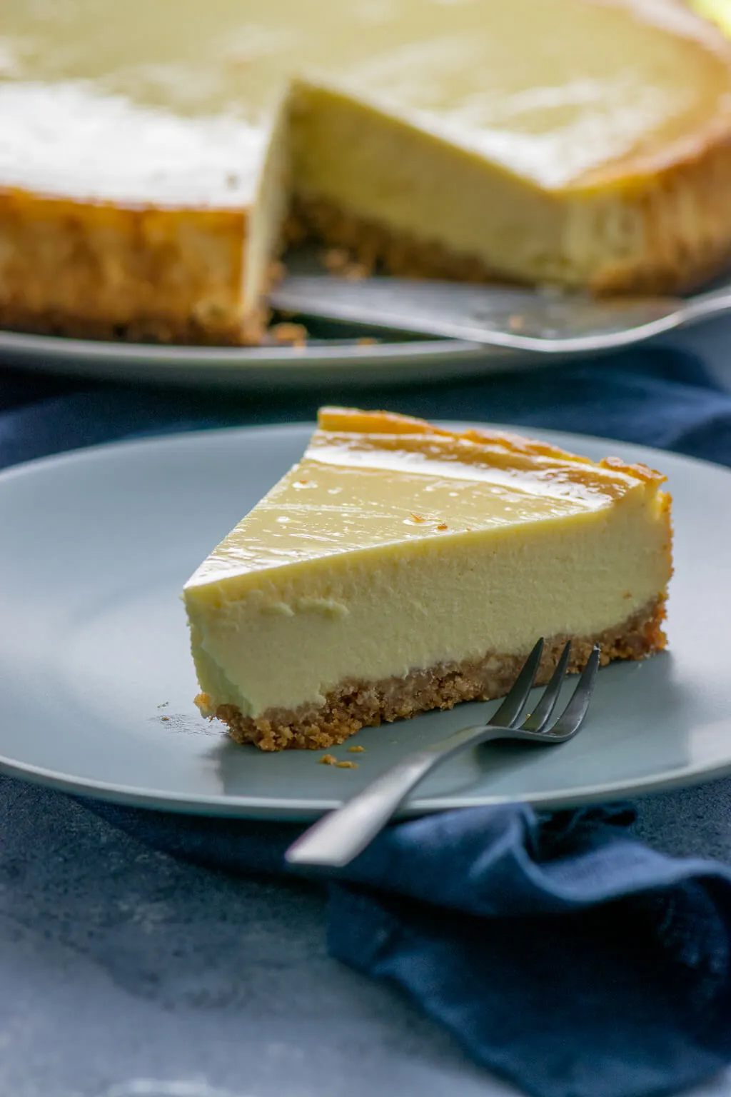Ein Ansicht des cremigen New York Cheesecakes mit einer perfekten goldbraunen Kruste auf einem Holztisch