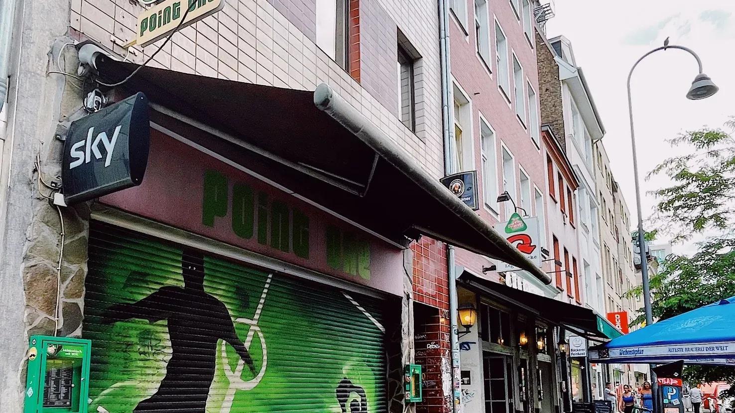 Ein Blick in die lebhafte Sportsbar Point One in Köln-Ehrenfeld, wo Fußballfans auf Großbildleinwänden mitfiebern.