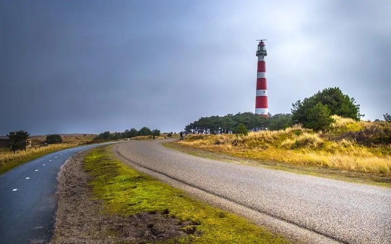 Ein breiter Sandstrand mit einem malerischen Leuchtturm im Hintergrund auf Ameland