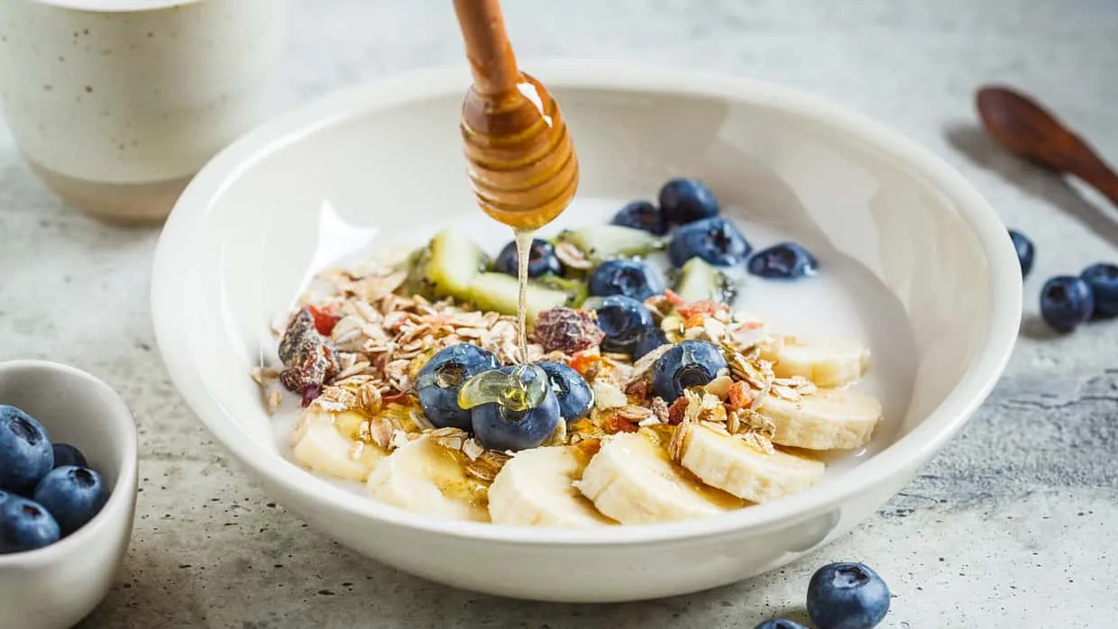 Ein bunter Magerquark mit verschiedenen Toppings wie Früchten, Nüssen und Samen, angerichtet in einer Schale.