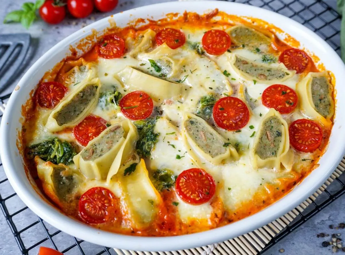 Ein bunter Maultaschen-Auflauf mit Spinat und Tomatensoße, frisch aus dem Ofen und bereit zum Servieren