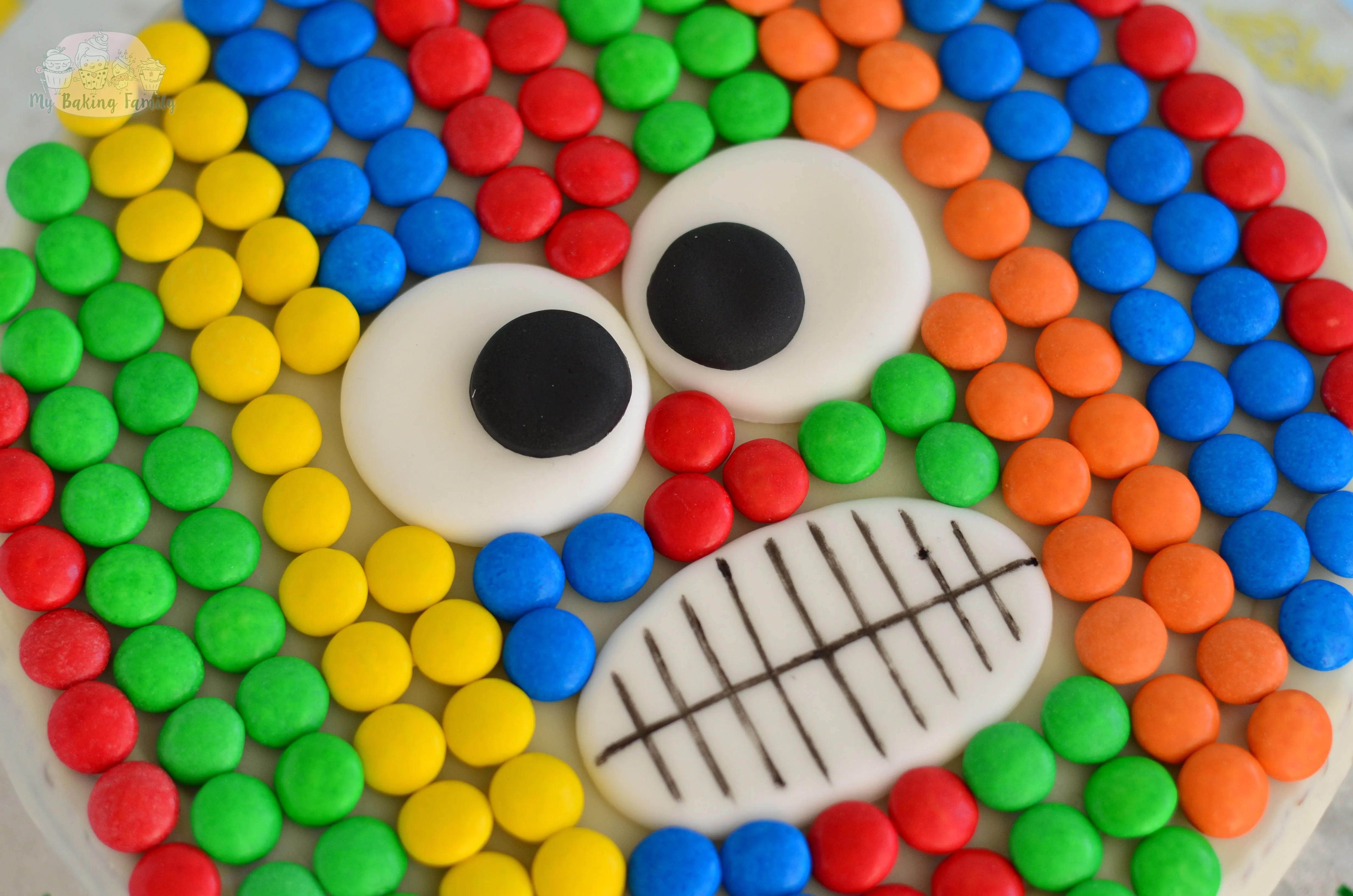 Ein bunter Monster Geburtstagskuchen mit Augen und Schokolinsen-Verzierungen