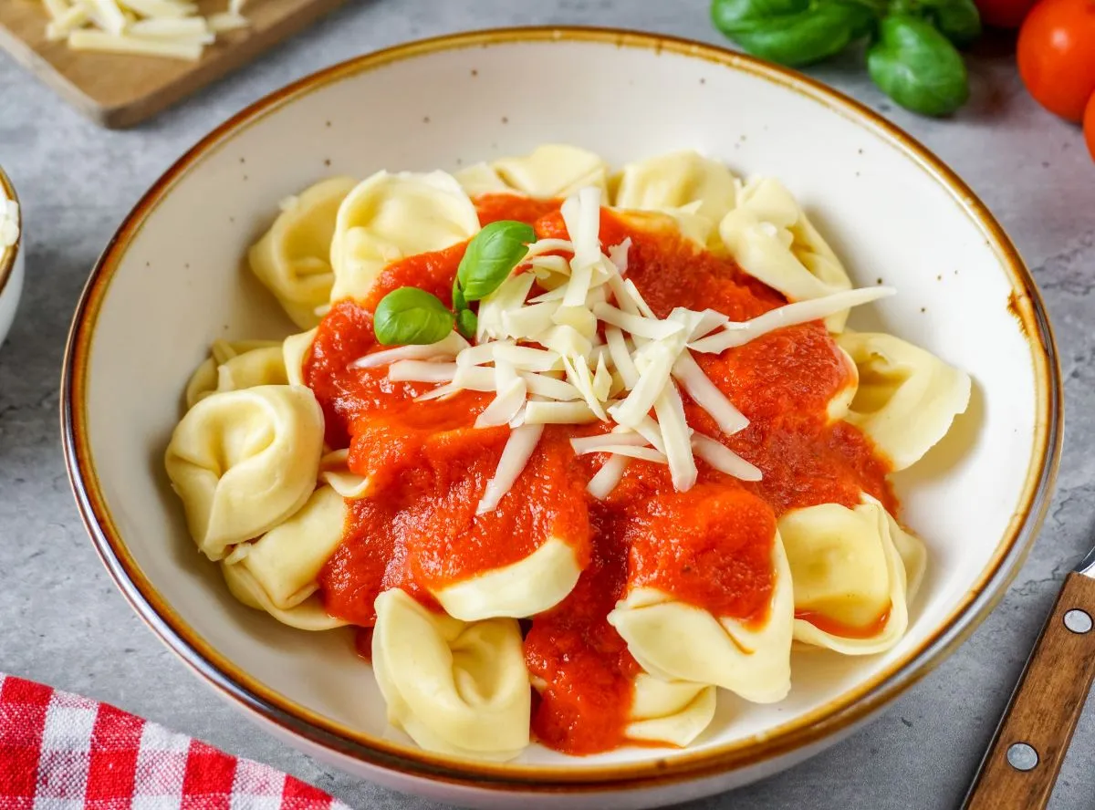 Ein bunter Teller mit Tortellini und frischer Tomatensoße, angerichtet für eine Mahlzeit