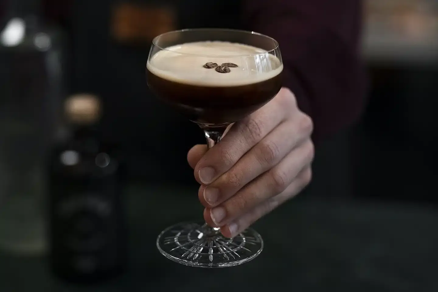 Ein elegant angerichteter Espresso Martini in einem Cocktailglas, garniert mit Kaffeebohnen