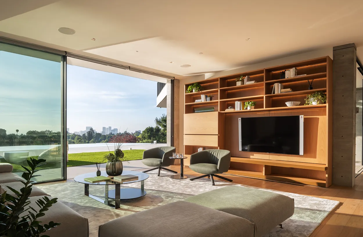 Ein elegantes Wohnzimmer mit modernen Möbeln und großen Fenstern, die einen weiten Ausblick bieten.