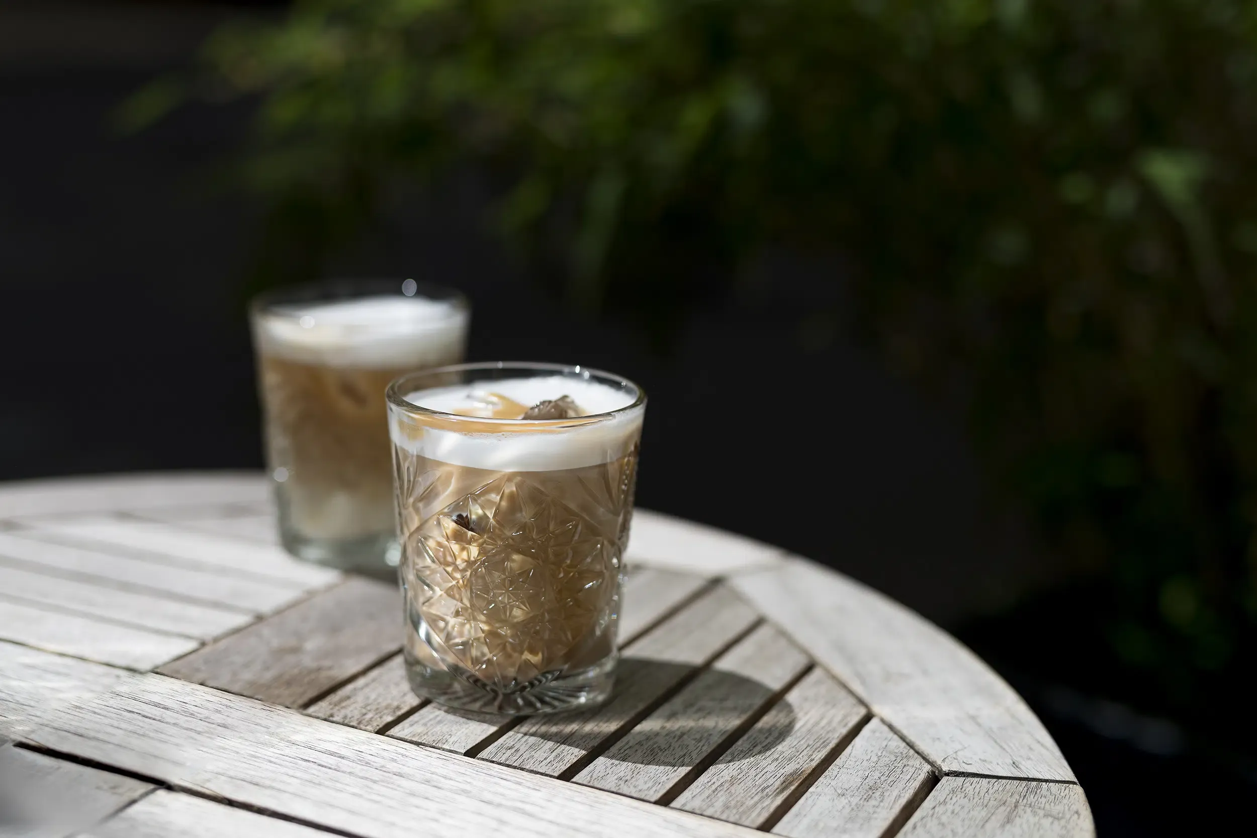 Ein erfrischender Iced Latte in einem Glas, geschichtet mit Eis, Milch und Cold Brew