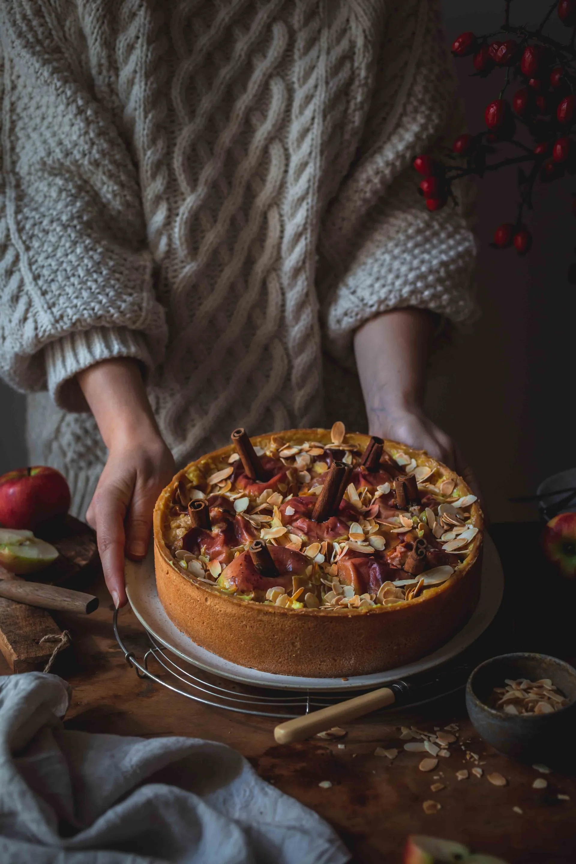 Ein fertig gebackener Bratapfelkuchen mit Zimtstange, aufgeschnitten und bereit zum Servieren