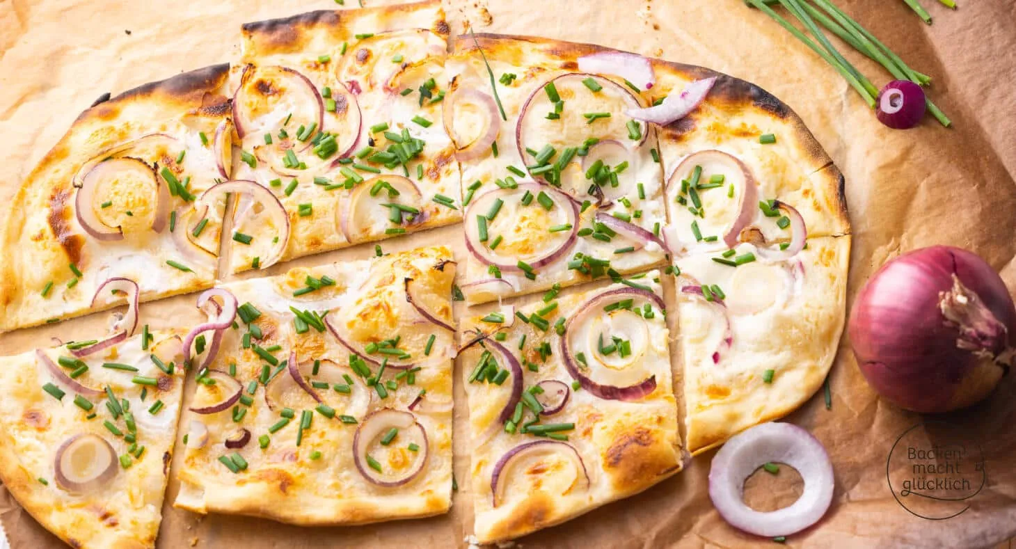 Ein fertig gebackener, goldbrauner vegetarischer Flammkuchen, bestreut mit frischem Schnittlauch, bereit zum Servieren