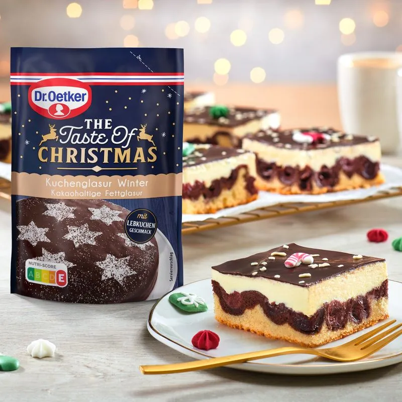 Ein festlich dekorierter Weihnachtskuchen mit glänzender Glasur und Zuckerstreuseln