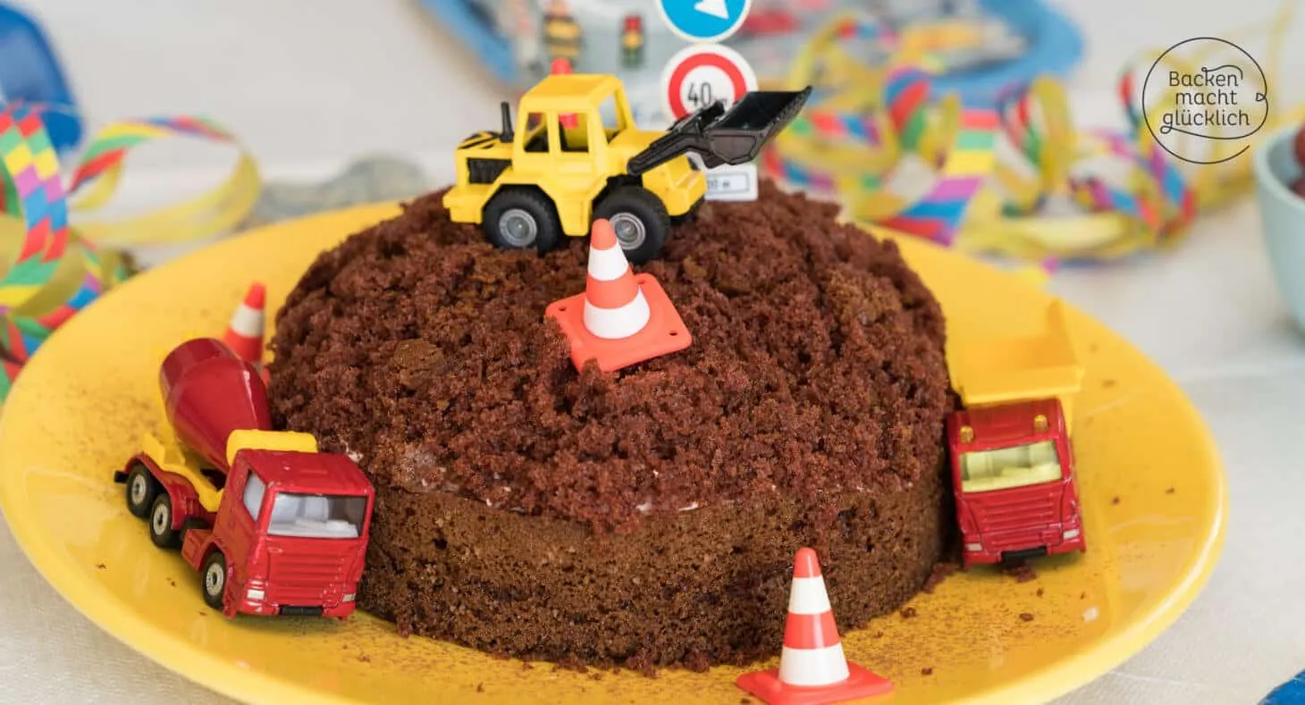 Ein festlicher Baustellen Geburtstagskuchen, verziert mit Spielzeugbaggern und Verkehrsschildern, bereit für die Kinderparty.