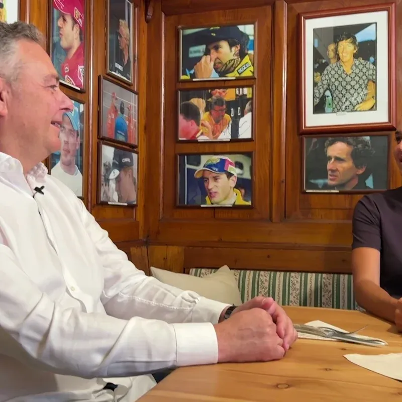 Ein Formel-1-Wagen rast mit hoher Geschwindigkeit über die Rennstrecke, umgeben von Streckenbegrenzungen und Tribünen.